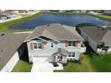 Two-story home with orange shutters and a pond in the background at 421 Chayne Pl, St Cloud, FL 34771