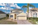 Charming two-story home featuring a well-manicured lawn, brick driveway and attached two-car garage at 435 Gleneagles Dr, Davenport, FL 33897