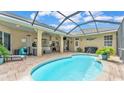 Outdoor pool featuring a covered patio with lounge seating, a bar, and an outdoor kitchen at 5345 Bloomfield Blvd, Lakeland, FL 33810