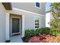 Inviting front entrance featuring a gray door and manicured landscaping with pink flowers at 5531 Keaton Springs Dr, Lakeland, FL 33811