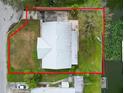 Aerial view of a property with a metal roof and canal access, outlined in red to show property lines at 5716 Gibson Shores Dr, Lakeland, FL 33809