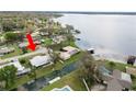 Aerial view of a waterfront home with a metal roof on a canal with easy access to a large lake at 5716 Gibson Shores Dr, Lakeland, FL 33809