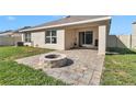Inviting backyard with paver patio, cozy firepit, and sliding glass doors enhancing outdoor living at 6769 Se 3Rd Loop, Ocala, FL 34472