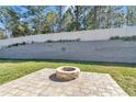 Well-maintained backyard featuring a paver patio, fire pit, and a retaining wall for added privacy and visual appeal at 6769 Se 3Rd Loop, Ocala, FL 34472