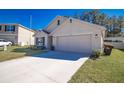 Single-story home with a two-car garage, concrete driveway, and landscaped front yard at 6769 Se 3Rd Loop, Ocala, FL 34472