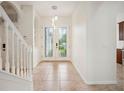 Bright foyer features a staircase, tile flooring, and elegant double doors with glass inserts at 1108 Stoney Creek Blvd, Lakeland, FL 33811