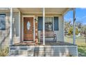 Inviting front porch with rocking bench, wood door, and stylish accents for relaxation at 111 Klein Ct, Lakeland, FL 33813