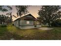 Rear view of a cozy single-story house with an enclosed back porch and a well-maintained yard at 1243 Olive St, Lakeland, FL 33815