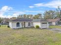 Quaint single-story home with an attached two car garage and well-maintained front yard at 1415 Pinewood Ave, Lakeland, FL 33803