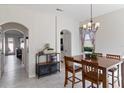 Open-concept dining area with wood table set, chandelier, and archway leading to other rooms at 14439 Prunningwood Pl, Winter Garden, FL 34787