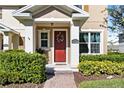 Inviting front entrance with red door, tasteful landscaping and decorative house number display at 14439 Prunningwood Pl, Winter Garden, FL 34787