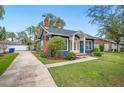 Charming blue home featuring a well-manicured lawn and concrete driveway at 1618 Robertson St, Lakeland, FL 33803