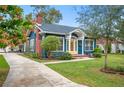 Charming blue home with a brick chimney, complemented by a well-manicured lawn at 1618 Robertson St, Lakeland, FL 33803