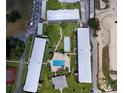 Aerial view of the complex showcasing multiple buildings, green space, and sparkling pool at 1700 6Th Nw St # A36, Winter Haven, FL 33881