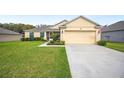 Well-maintained single-story home with green lawn, two-car garage, and beautiful landscaping at 1888 Creeks Vista Blvd, Lakeland, FL 33810