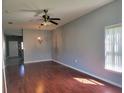 Large living room boasts stylish lighting, hardwood flooring, a window, and gray paint throughout at 2051 Winterset Dr, Lakeland, FL 33813