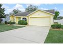 Charming home featuring a two-car garage and a well-maintained lawn with manicured shrubs at 2170 Country Manor St, Bartow, FL 33830