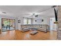 Bright living room featuring a spacious sectional, wood floors, and access to outdoor space at 2330 Peterson Rd, Lakeland, FL 33812