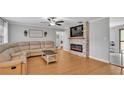 Cozy living room features a stone fireplace, modern ceiling fan and laminate wood flooring at 2330 Peterson Rd, Lakeland, FL 33812