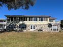 Rear exterior view of a two-story house with stone accents and a lawn at 330 Callitris Ave, Polk City, FL 33868