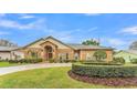 Charming brick home with a well-manicured lawn and lush landscaping at 4769 Highlands Place Cir, Lakeland, FL 33813