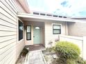 Inviting entrance showcasing a painted door and lush landscaping at 5225 Imperial Lakes Blvd # 49, Mulberry, FL 33860