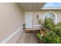 Inviting front entrance with a white door, decorative plants, a 'hello' mat, and stylish exterior lighting at 5252 Montserrat Dr, Lakeland, FL 33812