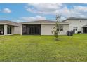 Green backyard featuring lawn and view of the back of the house with screened lanai at 5431 Arlington River Dr, Lakeland, FL 33811