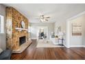 Cozy living room with a stone fireplace, hardwood floors, and a view of the dining room at 624 Woodward St, Lakeland, FL 33803