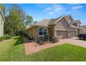 Beautiful home featuring a well-manicured lawn, brick walkway, and a two-car garage at 6329 Torrington Cir, Lakeland, FL 33811