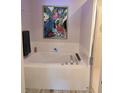 Bright bathroom with a large tub, tiled walls, and a decorative floral print at 6397 Torrington Cir, Lakeland, FL 33811