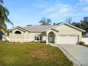 Charming single-story home featuring a well-manicured lawn and attached two-car garage at 7211 Scenic Hills Blvd, Lakeland, FL 33810