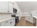 Modern kitchen featuring white cabinets, stainless steel appliances, and wood-look floors at 750 W Vine St, Bartow, FL 33830