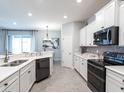 Modern kitchen featuring stainless steel appliances, white cabinets, and a stylish backsplash, ideal for cooking at 7609 Sw 107Th Ln, Ocala, FL 34480