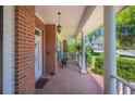 Inviting front porch features brick flooring and classic white columns at 940 Ashton Oaks Cir, Lakeland, FL 33813