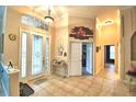 Bright foyer with tiled floor, chandelier, and view of the front door at 1 Lake Eloise Ln, Winter Haven, FL 33884