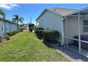 View of a well-maintained lawn with landscaping leading to the side of a home with a screened in porch at 1155 Motorcoach Dr, Polk City, FL 33868