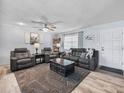 Cozy living room featuring a plush sofa, recliner set, modern decor, and wood-look flooring at 1310 Parker Rd, Lakeland, FL 33811