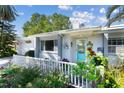 Inviting front porch featuring a vibrant blue door, charming plants, and a decorative welcome sign at 2020 Indian Trl, Lakeland, FL 33813