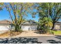 Charming home featuring a two-car garage and lush landscaping with mature trees at 2126 Sandy Hook, Lakeland, FL 33813