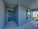 Close-up of the home's entrance with a gray front door and window, creating an inviting entryway at 236 Talladega Ln, Polk City, FL 33868