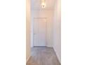 Hallway features neutral walls, a light fixture, and tile floors, creating a clean, modern feel at 2613 Sundance Cir, Mulberry, FL 33860