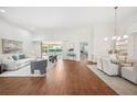 Bright living room featuring hardwood floors, white walls, comfortable seating, and a view of the pool area at 2900 Grasslands Dr, Lakeland, FL 33803