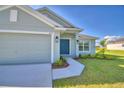 Charming home with a covered entryway, featuring lush landscaping and a well-maintained two-car garage at 4123 Tullamore Ln, Auburndale, FL 33823