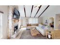 Bright living room with a stone fireplace, vaulted ceiling with exposed beams, and comfortable seating at 4641 Devon Ave, Lakeland, FL 33813
