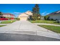 Pleasant single-story home with a well-kept lawn and a concrete driveway on a sunny day at 474 Cedar Glen Dr, Lake Alfred, FL 33850