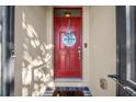Elegant red front door with decorative wreath and modern hardware for a welcoming entrance at 474 Cedar Glen Dr, Lake Alfred, FL 33850