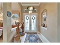 Elegant foyer featuring double doors, tile flooring, high ceilings, and decorative art pieces at 565 Osprey Landing Dr, Lakeland, FL 33813