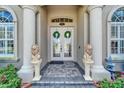 Elegant front door entrance, flanked by lion statues and flowerbeds, offering classic curb appeal at 565 Osprey Landing Dr, Lakeland, FL 33813