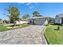 Attractive single-story home featuring a paver driveway and landscaped front yard at 6217 Peacock Run, Lakeland, FL 33809